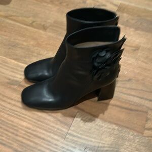 Tory Burch chunky heel ankle boot with flower detail and back zip.